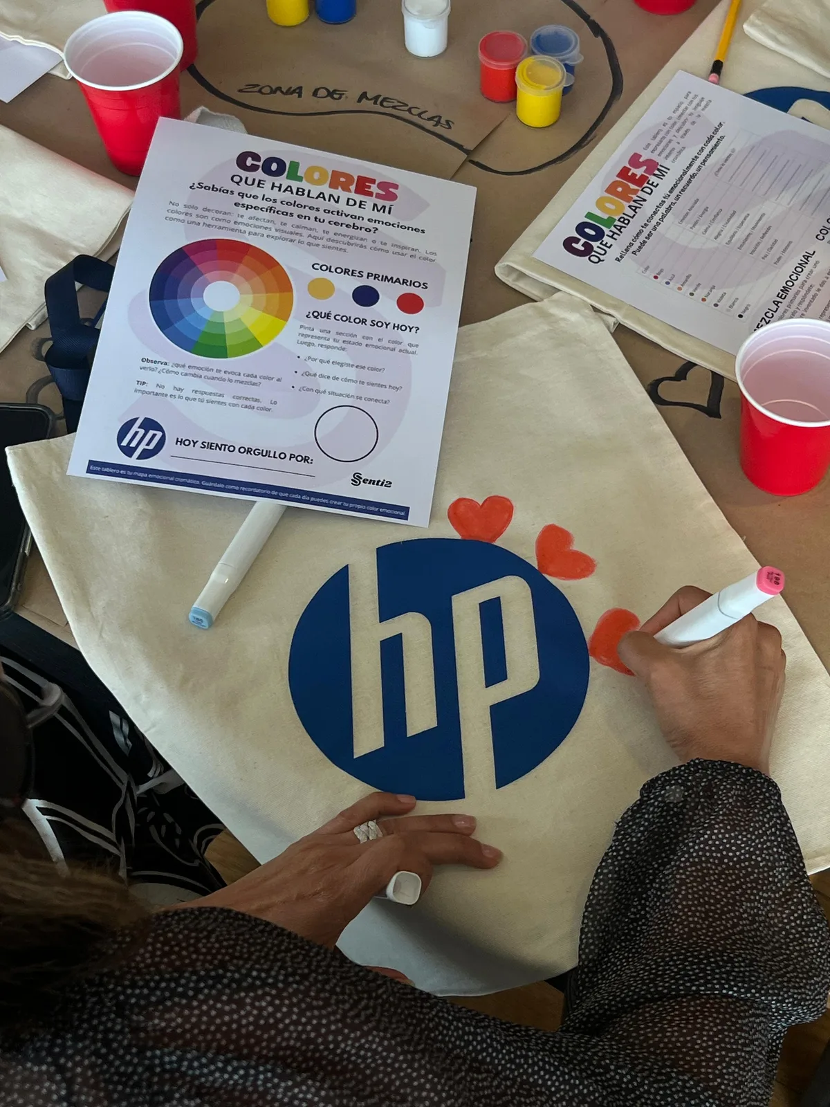 Una participante pinta un diseño sobre una bolsa de tela.