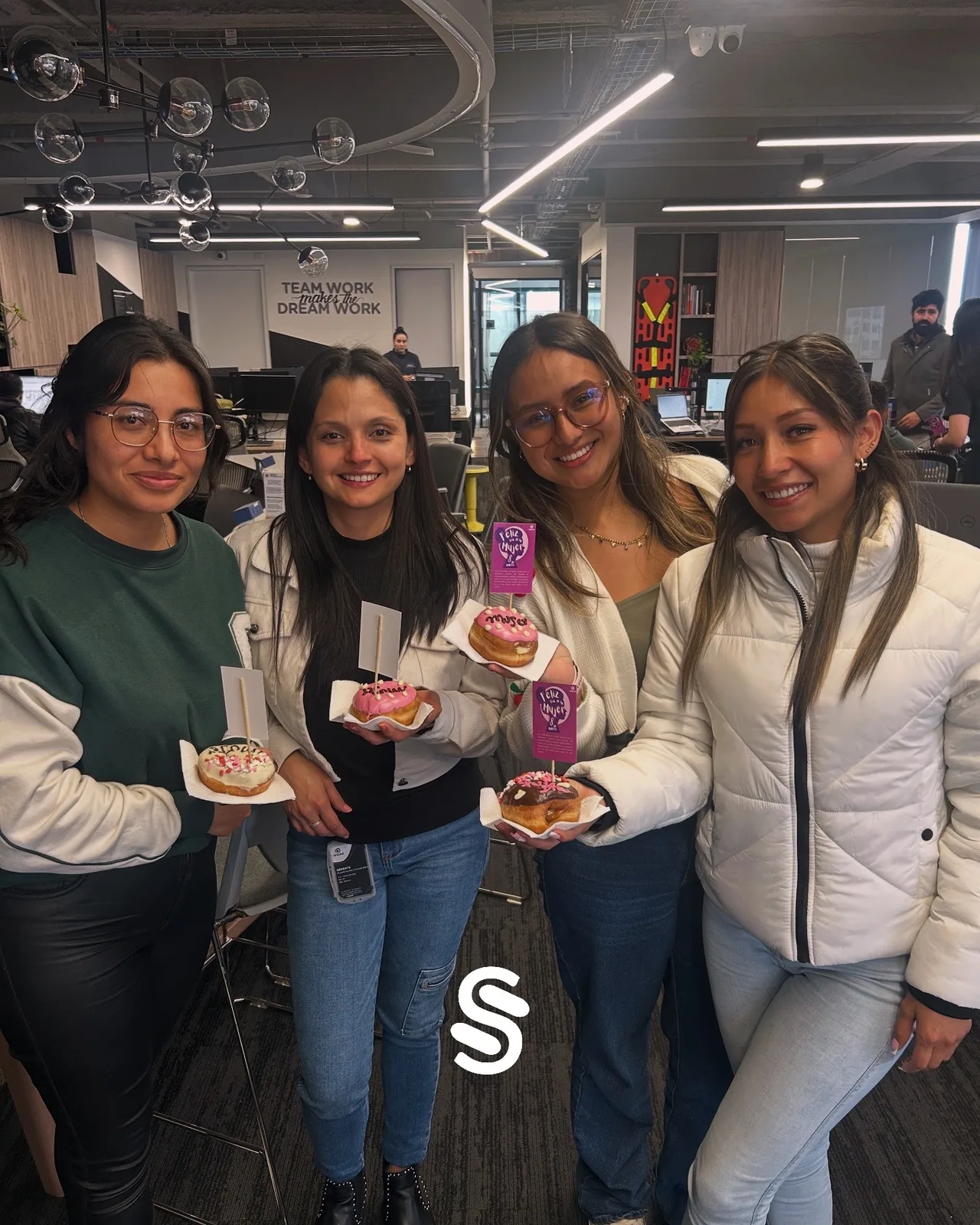 Un grupo de participantes comparte obsequios y sonríe durante un encuentro.