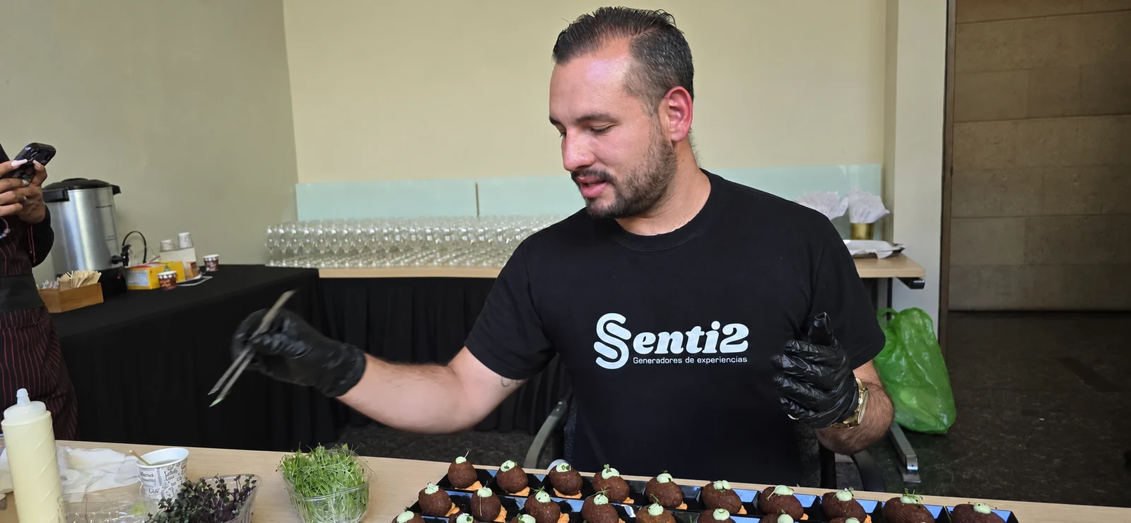 Un integrante del equipo Senti2 prepara una mesa de alimentos.